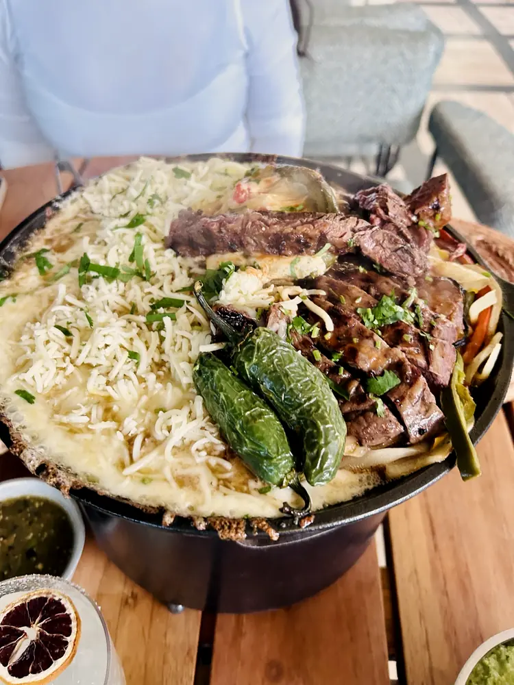 A shared cast-iron dish served family-style at a Becoming Beautifully gathering.